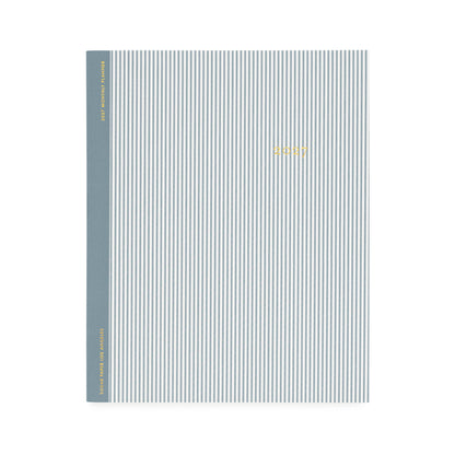 A flat monthly planner with a blue pinstripe pattern with '2027' stamped on cover in gold foil with a dusty blue tape binding