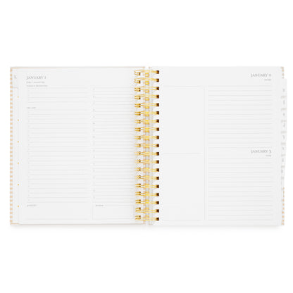 An open spiral-bound planner with white pages with grey ink with daily planning pages with notes for 'today's priorities,' 'grateful for,' and 'dinner' plans