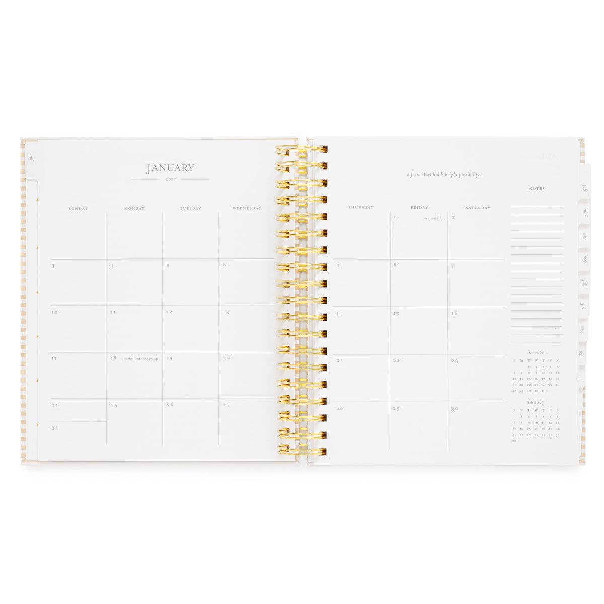 An open spiral-bound planner showing a January 2027 calendar spread with space for each day of the week and lined notes and a small monthly calendar for december 2026 + february 2027