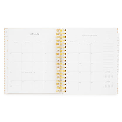 An open spiral-bound planner showing a January 2027 calendar spread with space for each day of the week and lined notes and a small monthly calendar for december 2026 + february 2027