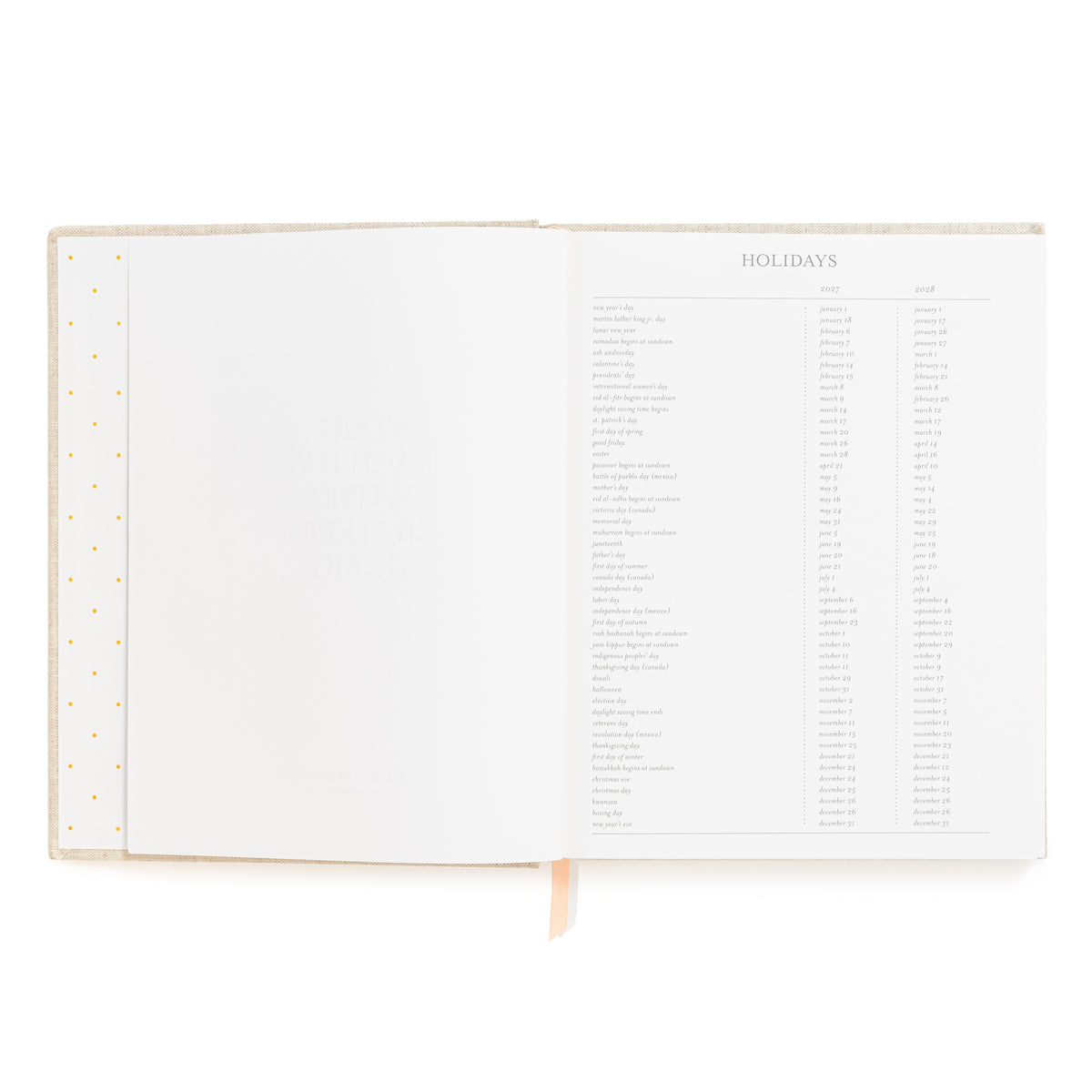 An open hardcover planner showing a printed holiday schedule page for 2027 and 2028, with blank lined pages on the left and a pink and white ribbon markers