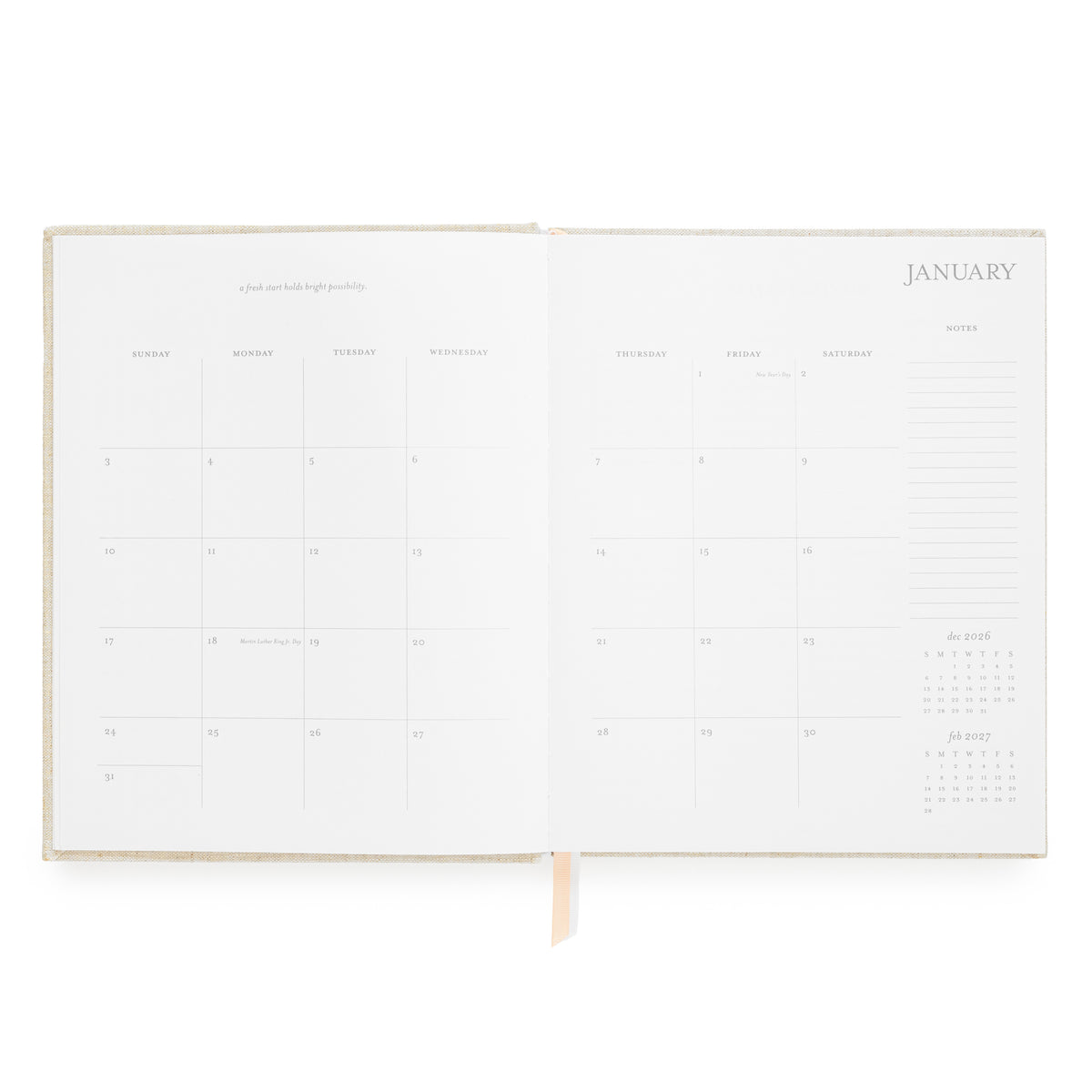 An open planner showing blank monthly calendar pages for January with light pink and white ribbon markers and notes section on the side