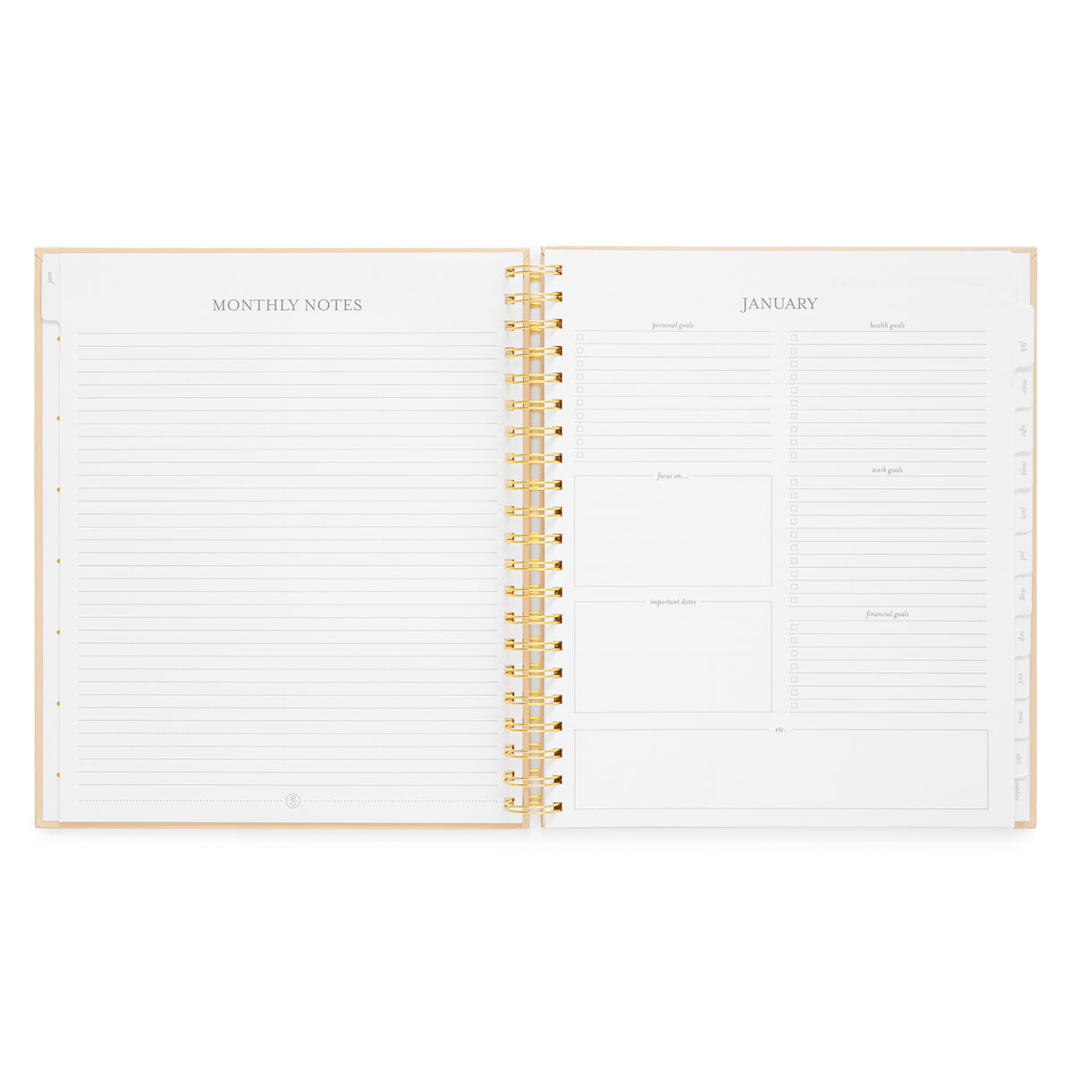An open spiral-bound planner showing lined monthly note pages on the left and a January goal setting section on the right with 'personal goals,' 'health goals,' 'work goals,' 'financial goals,' and more
