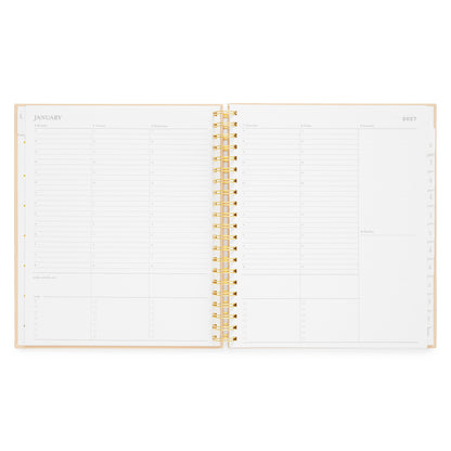 An open spiral-bound planner with white pages and a gold wire binding with daily layout with timed slots for each day of the week and blank box spaces for the weekend days
