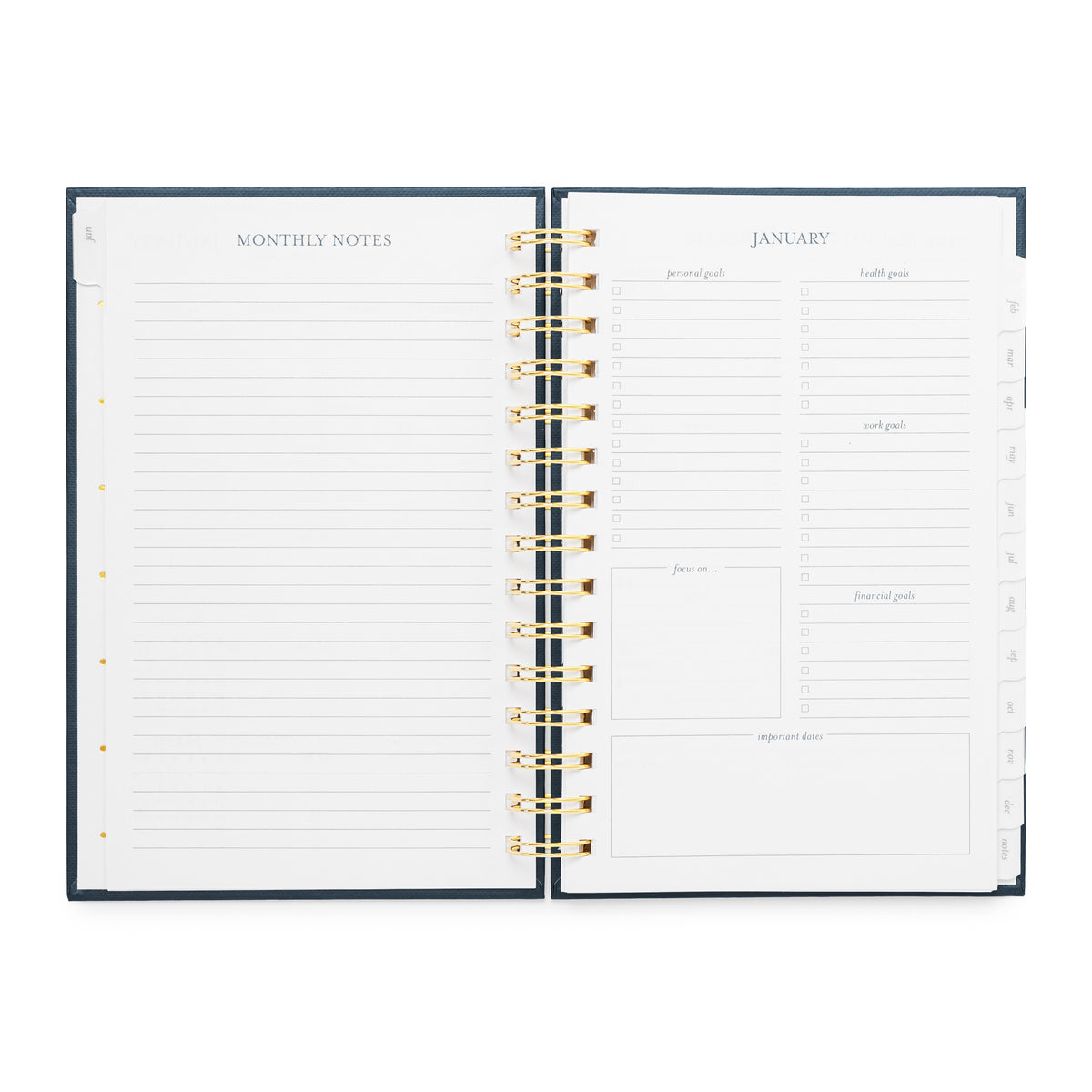An open spiral-bound planner showing the January page with lined monthly notes on the left and task and goal setting sections on the right with a dark navy cover