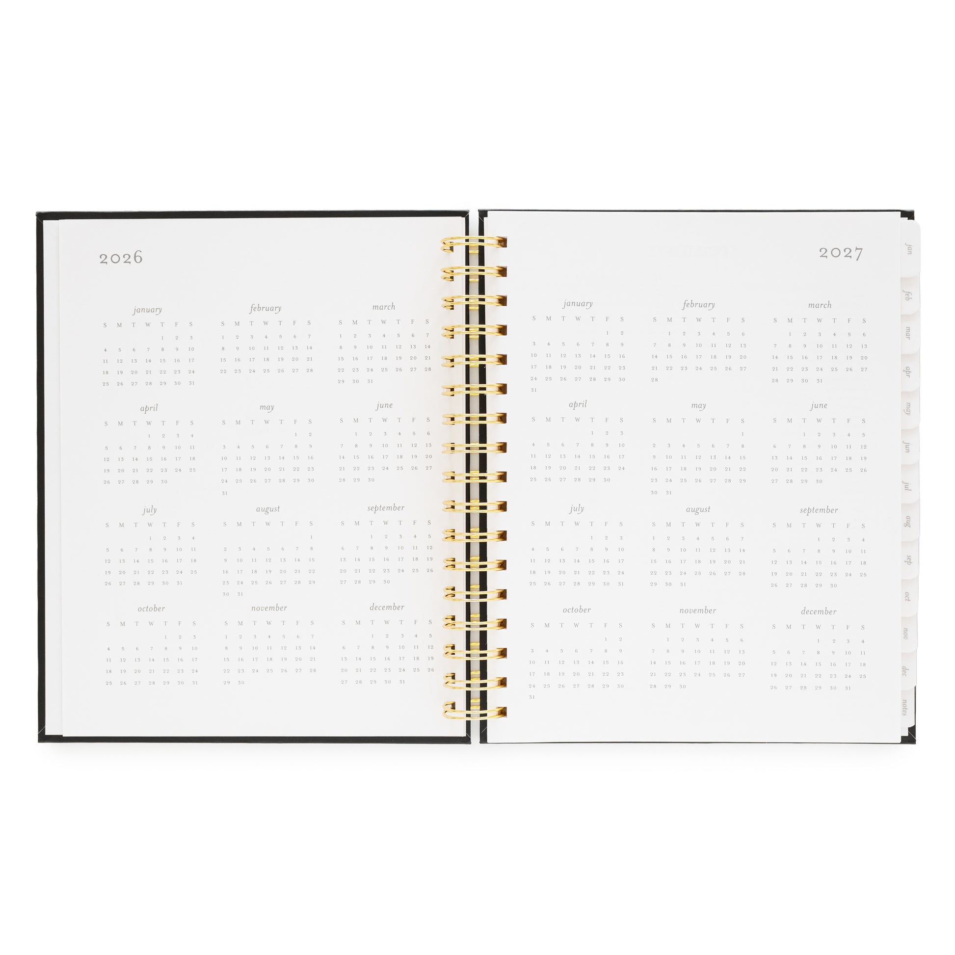 Open spiral planner with 2026 and 2027 calendar months with a gold spiral binding