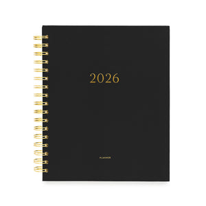 Black planner with gold spiral binding and '2026' printed on the cover