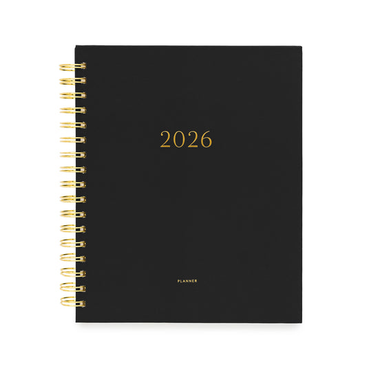 Black planner with gold spiral binding and '2026' printed on the cover