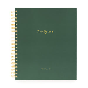 Green planner with gold spiral binding and 'twenty six' text on a white background