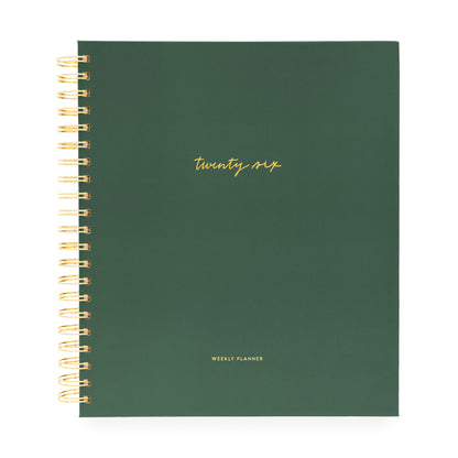 Green planner with gold spiral binding and 'twenty six' text on a white background