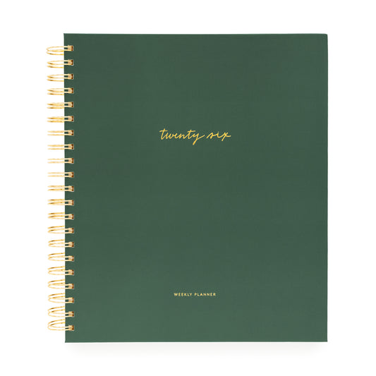 Green planner with gold spiral binding and 'twenty six' text on a white background
