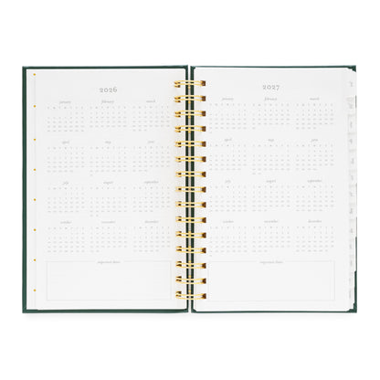 Open small spiral planner showing pages for 2026 and 2027 months