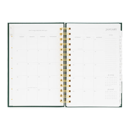 Open small spiral planner showing a monthly calendar layout for January 2026