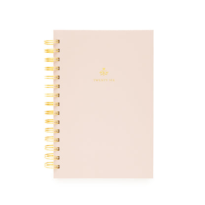 Blush pink planner with gold spiral binding with twenty-six on the cover and a god flower