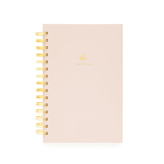 Blush pink planner with gold spiral binding with twenty-six on the cover and a god flower