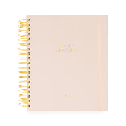 Blush pink daily planner with gold spiral binding and daily planner and 2026 in gold foil on the cover