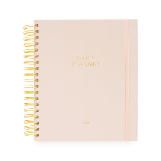 Blush pink daily planner with gold spiral binding and daily planner and 2026 in gold foil on the cover