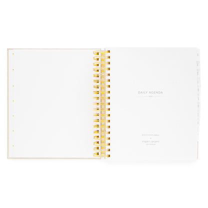 Open daily spiral planner with gold spiral binding with daily agenda 2026 and breathing room for sugar paper logo