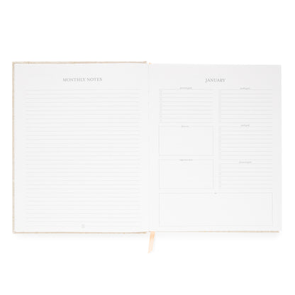 Interior of desk agenda with monthly notes and lined page and goals and prompts including personal, health, focus work, and financial goals and space for important dates and focus on