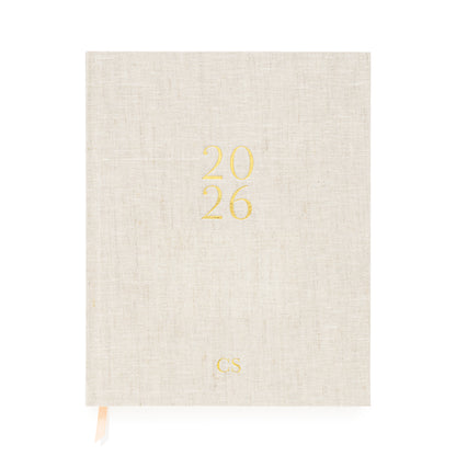 Flax desk agenda cover foil stamped with 2026 in gold foil with gold 'CS' initials and pink and white ribbon markers