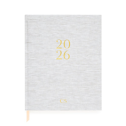 Grey and white stripe desk agenda with 2026 and 'CS' monogram initials stamped in gold foil