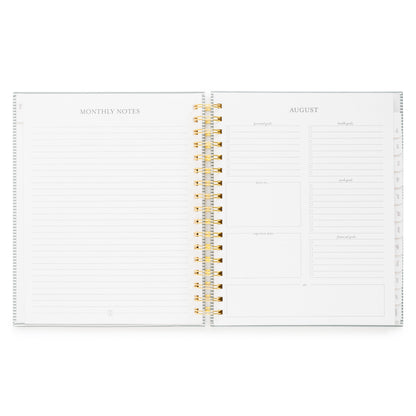 Open planner showing monthly notes and monthly guided prompts including 'personal goals,' 'health goals,' 'focus on,' 'work goals,' 'financial goals,' and 'important dates'