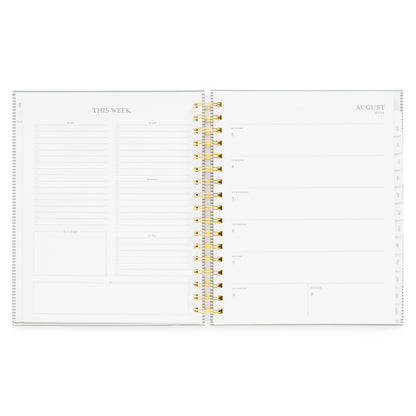 Open spiral academic planner showing the weekly layout with weekly prompts on the left and section of each day of the week on the right with august 2026 dates