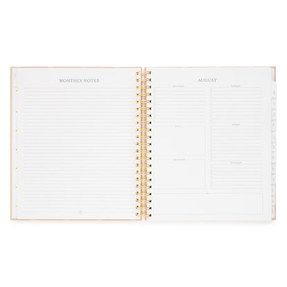 Open spiral planner layout with monthly notes on the left and august monthly guided prompts on the right with 'personal goals, health goals, focus on, work goals, financial goals, and important dates'