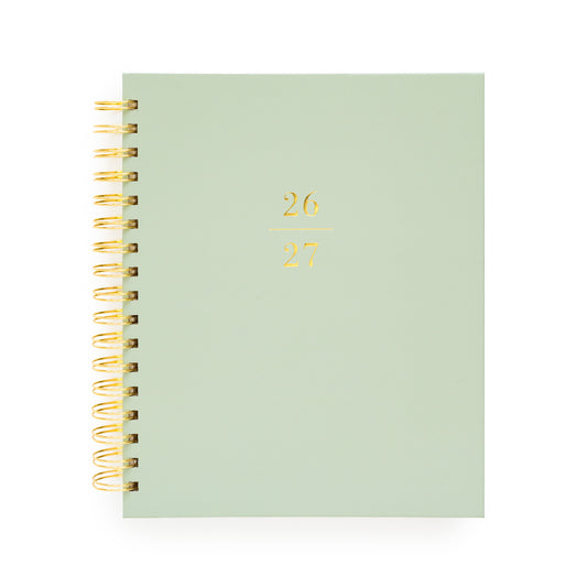 Light green planner with gold spiral binding and '26-27' in gold foil