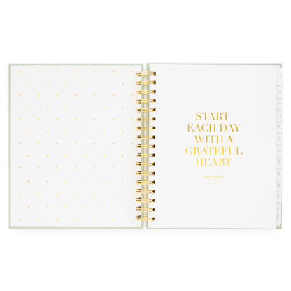 Open planner with polka dot page and 'start each day with a grateful heart' in gold foil on white background
