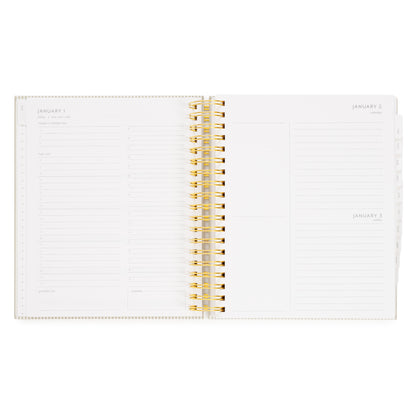 An open spiral-bound planner with gold wire binding, showing lined daily and weekly layout pages with 'today's priorities,' 'the list,' 'grateful for,' timed slots for the day, and 'dinner'. the grid on the right shows the weekend days with blank boxes and lines for jotting down the events planned