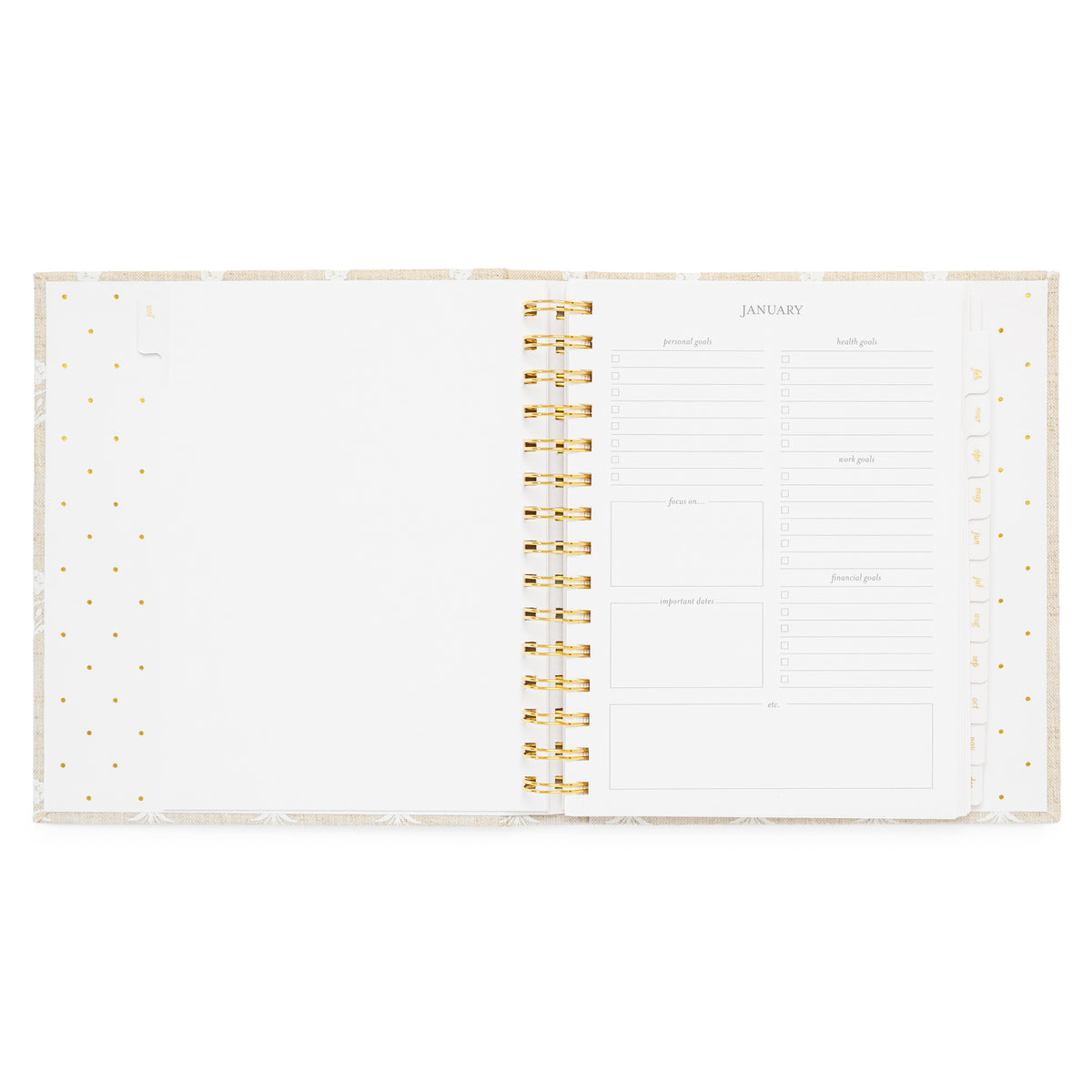 An open fabric spiral-bound planner with white pages with january monthly goal prompts on the right side
