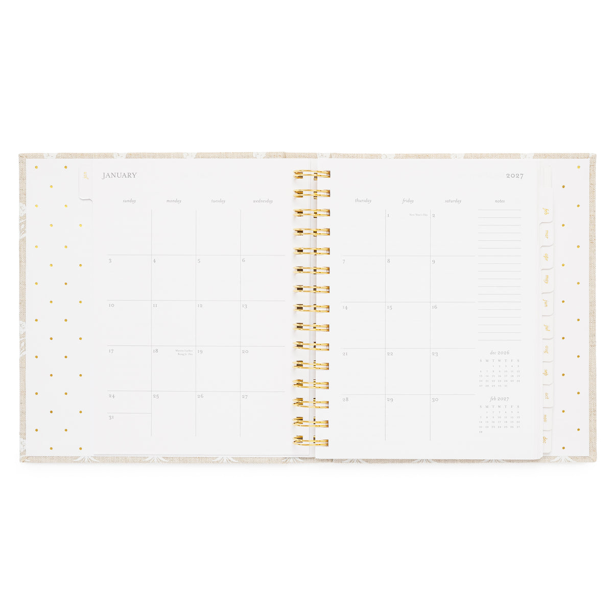 An open spiral-bound planner showing a January 2027 calendar monthly spread with gold spiral in the middle