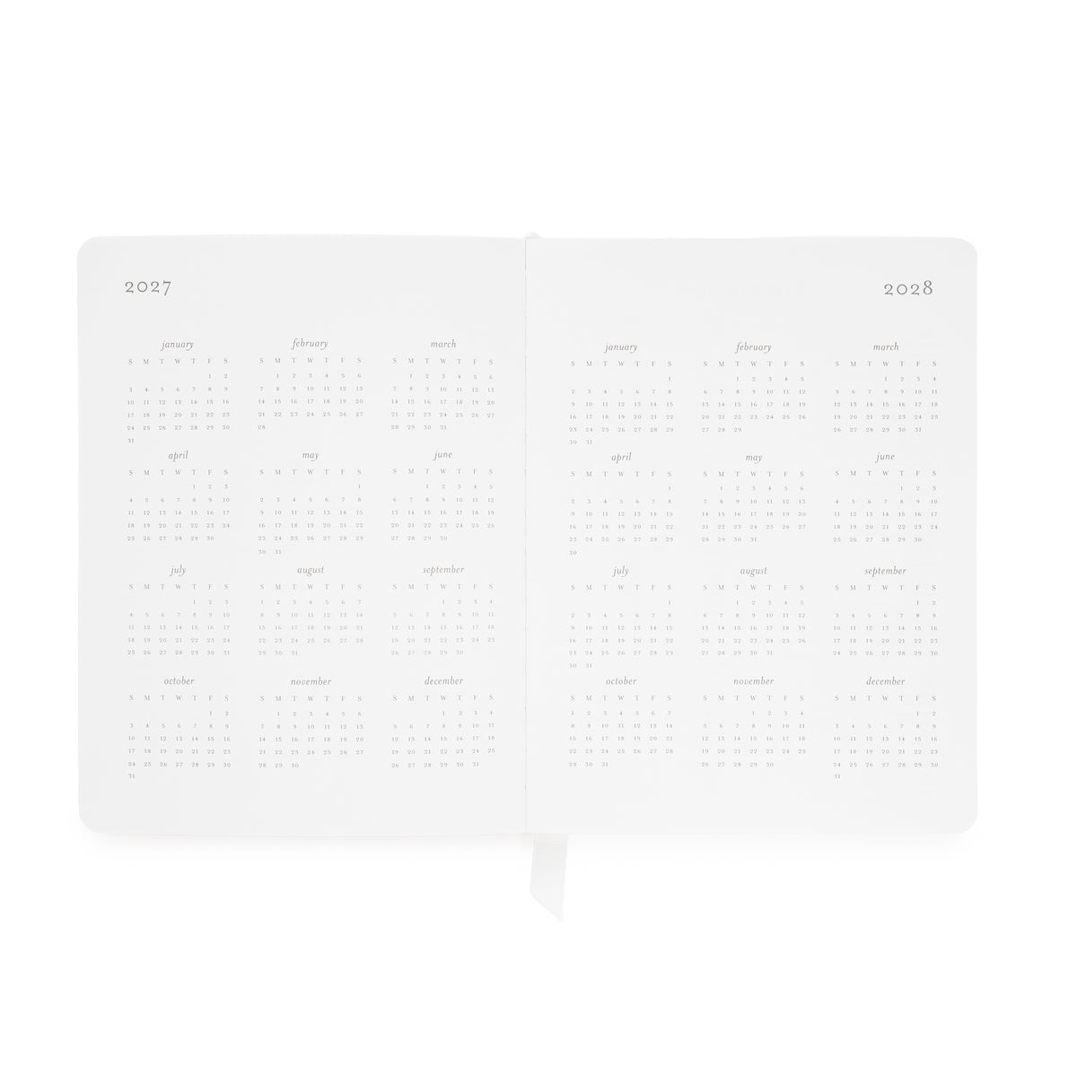 A white 2027-2028 planner shown open to two blank interior spread pages with monthly calendar grids for 2027 + 2028 dates and a small ribbon bookmark