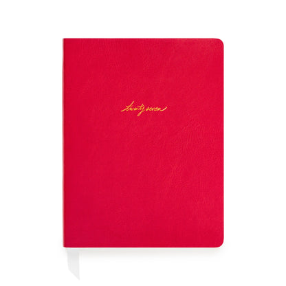 A red soft leather planner with gold foil script reading 'twenty-seven' on the front cover with white ribbon markers