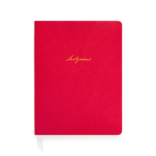 A red soft leather planner with gold foil script reading 'twenty-seven' on the front cover with white ribbon markers