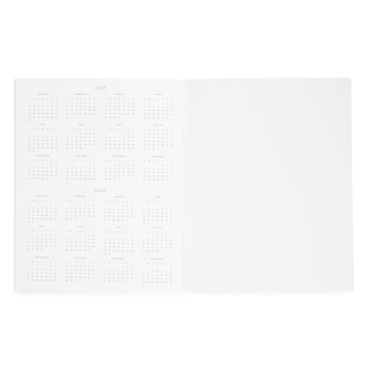An open white planner showing a left page with printed calendar grids for 2027 and 2028, and a blank right page