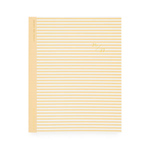 Yellow and white striped planner with '26 27' in gold foil on cover with yellow tape binding
