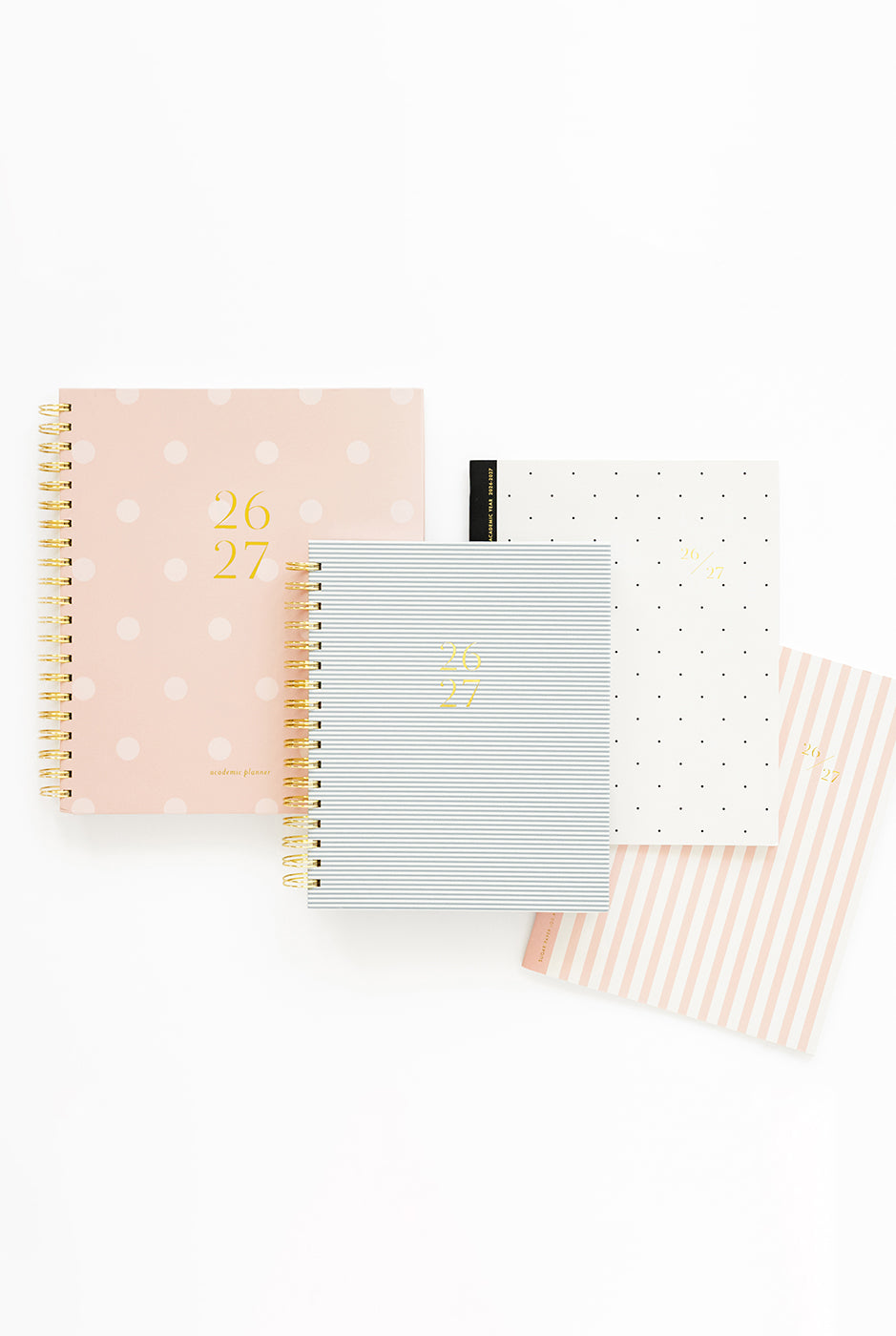 Four planners arranged on a white background. The notebooks feature pastel pink, light blue, white, and peach-and-white striped covers with gold numbers '26 27'.