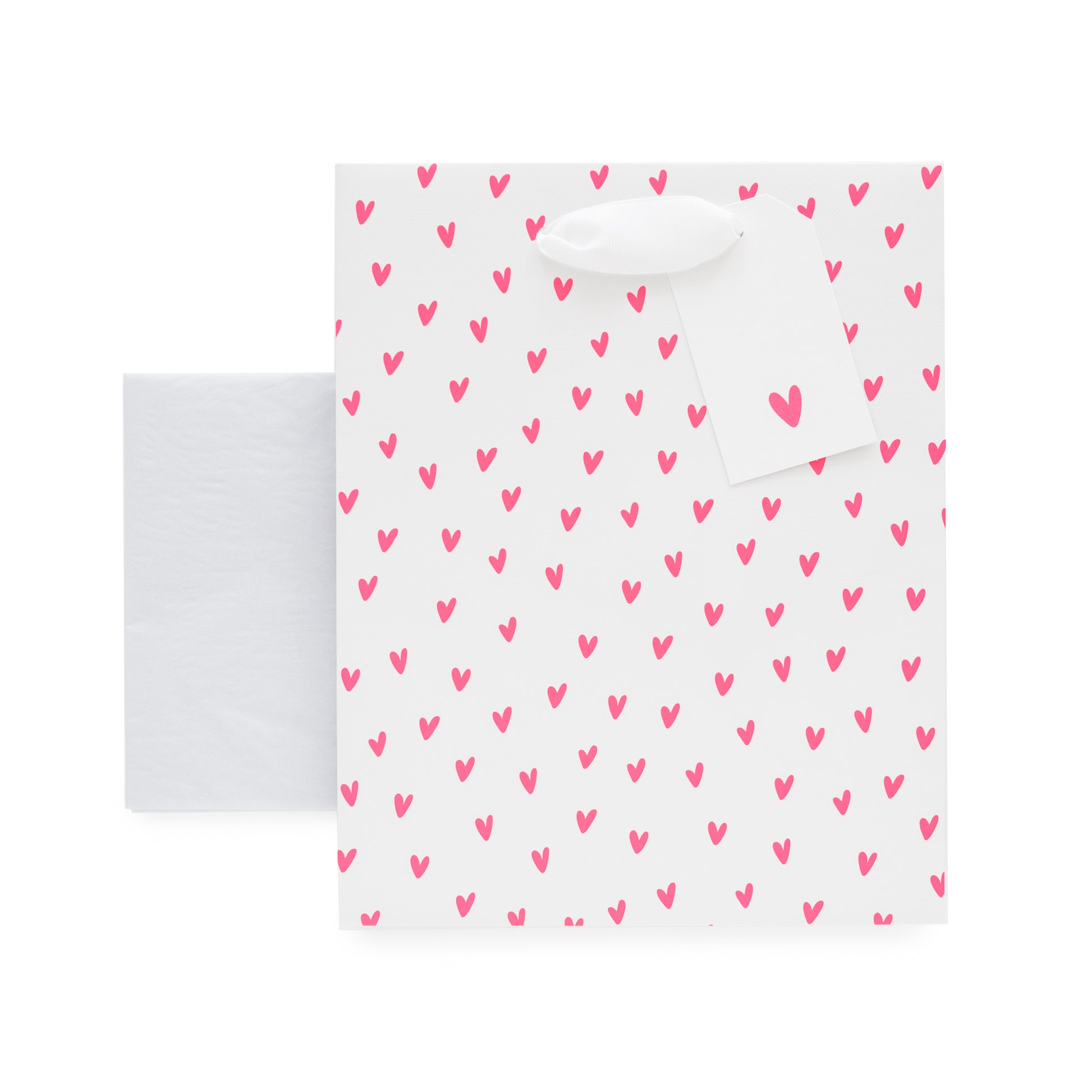 White gift bag with neon pink heart pattern, white gift tag with neon pink heart and stack of white tissue paper