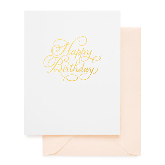 white happy birthday card with gold foil happy birthday in calligraphy paired with a pink envelope