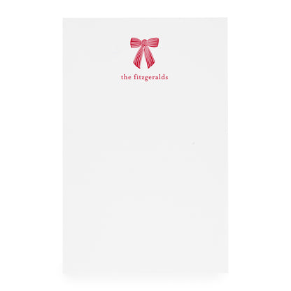 White paper with a red bow design and 'the fitzgeralds' text on white paper