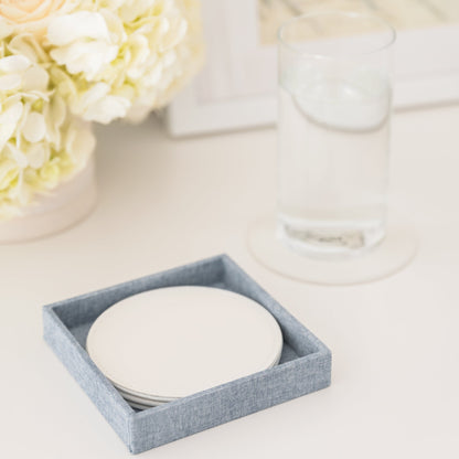 white coaster set on desk with water glass