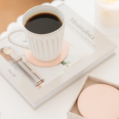 pink coaster on book with coffee mug