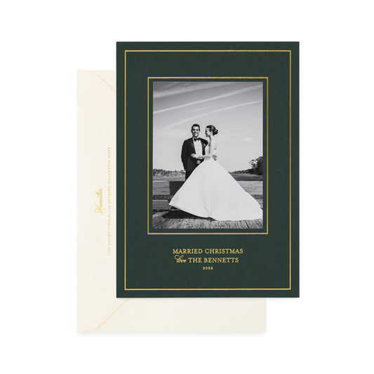 A holiday photo card on racing green paper, with gold foil details and a cream envelope.