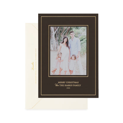 A holiday photo card on dark chocolate paper with gold foil details, shown with a cream envelope.