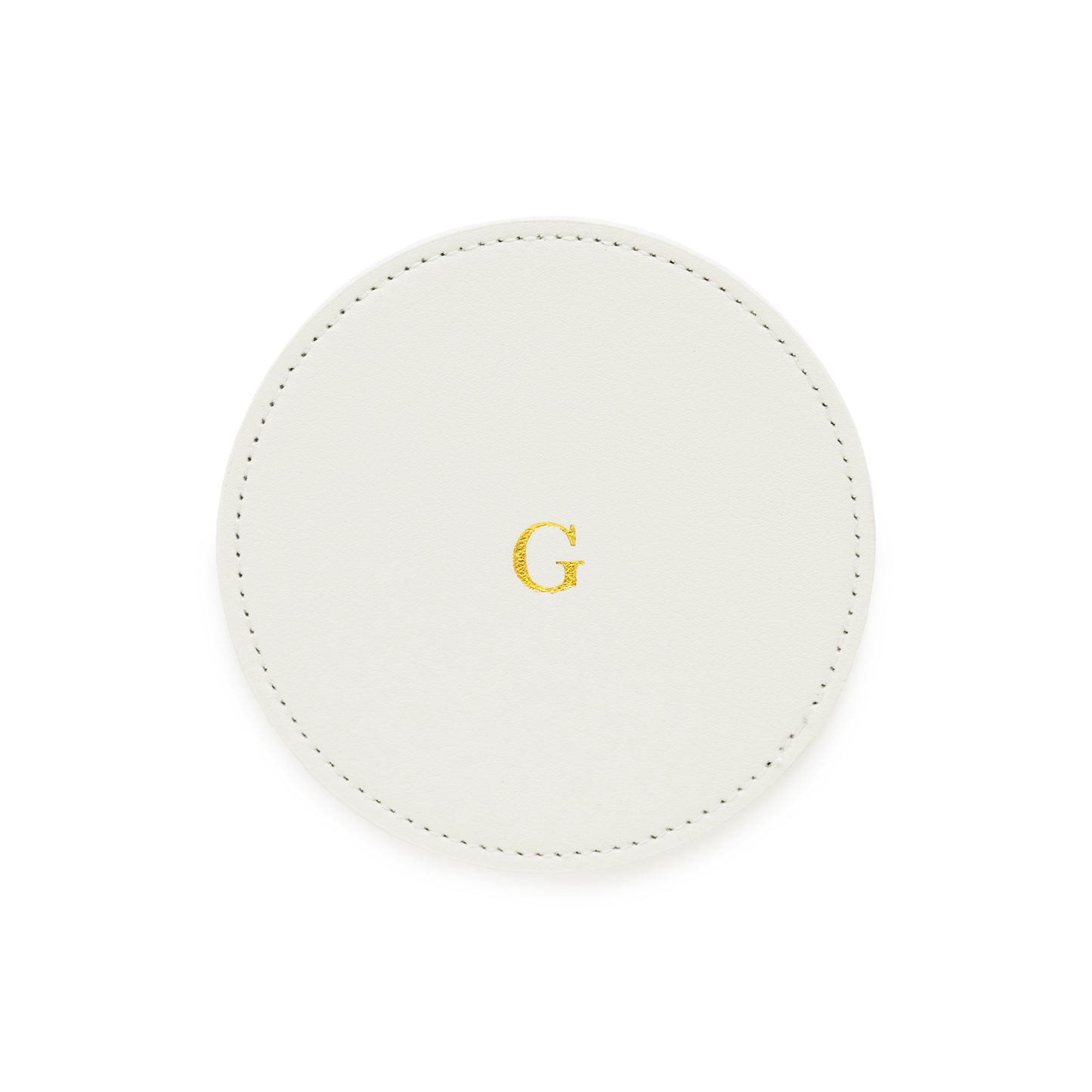 white monogrammed coaster with gold foil g on it