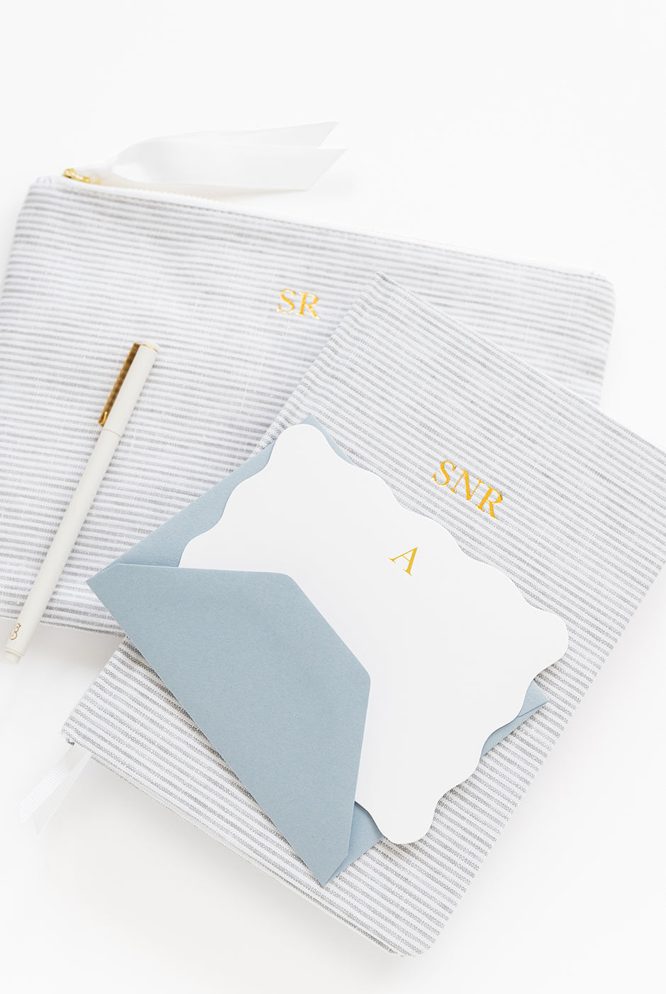 Stack of gray stripe products with white and blue note set on white background