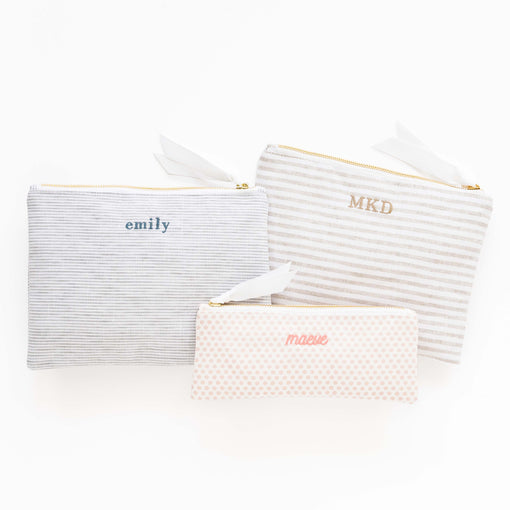 Three patterned pouches with personalized names on a white background