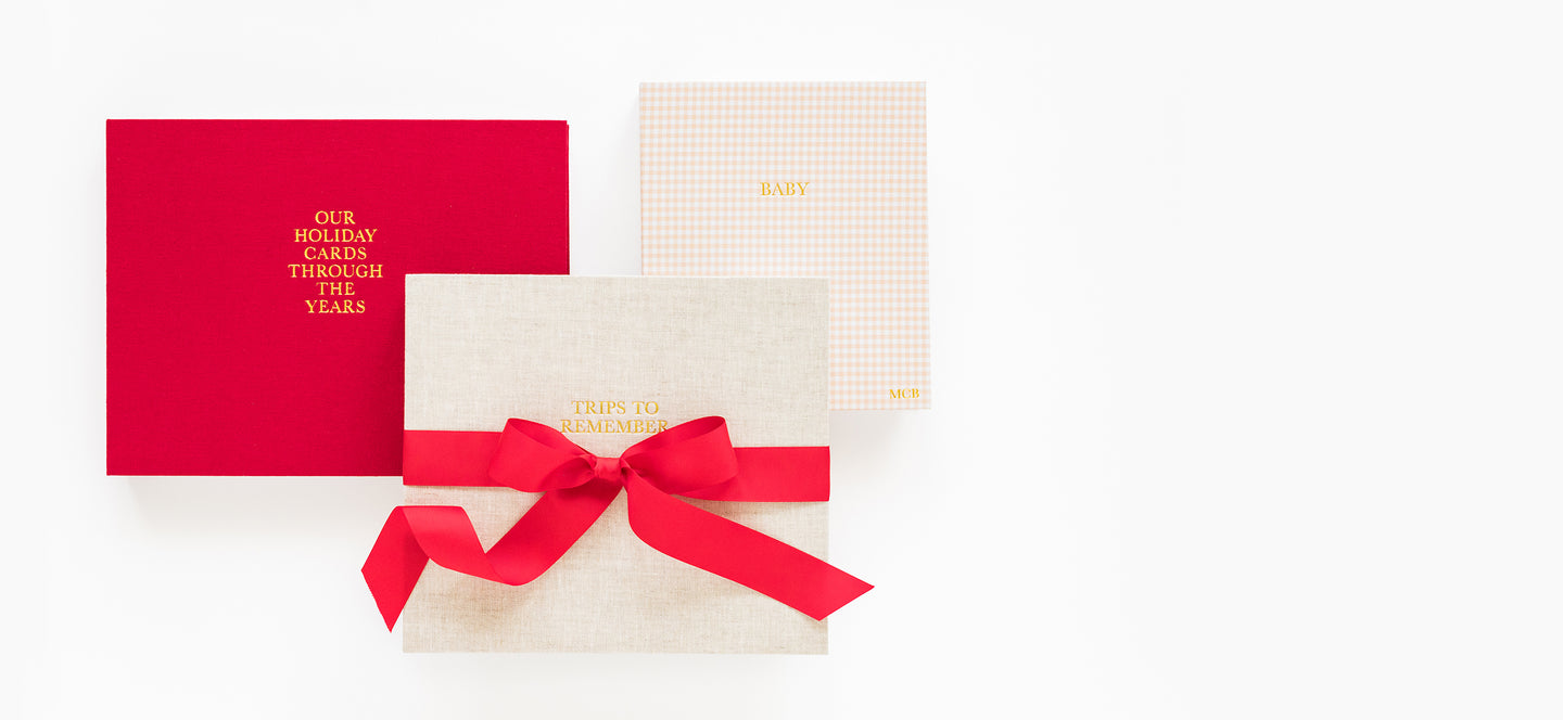 Red, flax, and pick check keepsake books with a red ribbon on a white background